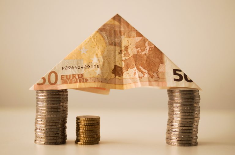 canva 50 euro banknote folding on top of piled coins