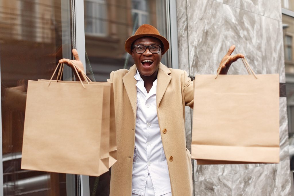 stylish black man in a city with shopping bags